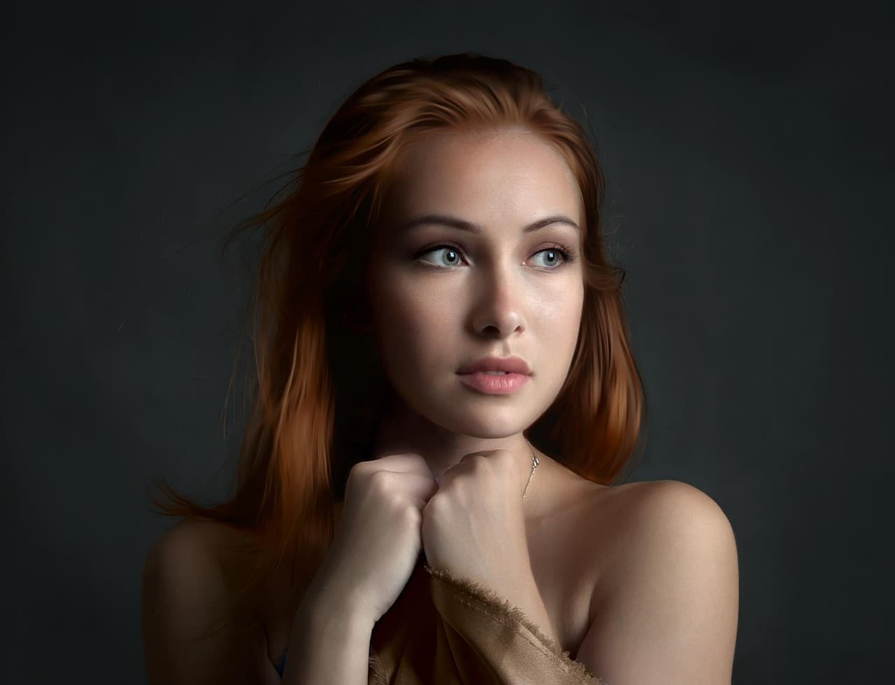 A woman with natural, defined brows and lashes, chin resting on her hands